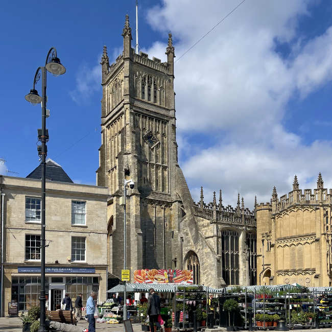 Cirencester Charter Market with a backdrop of Parish Church of St John Baptist, one of the largest parish churches in England - Photo Cirencester.co.uk